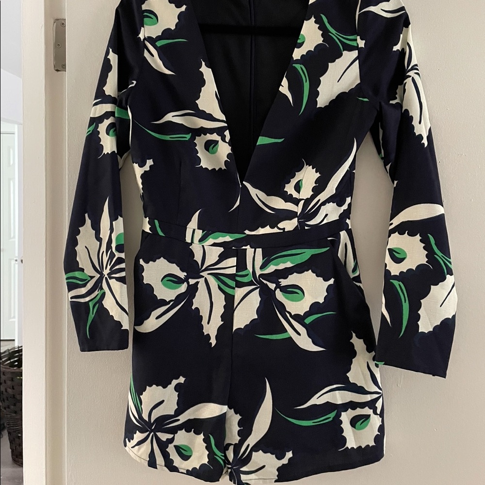 Navy blue romper, with white and green flower detail. Deep v neck Shows cleavage